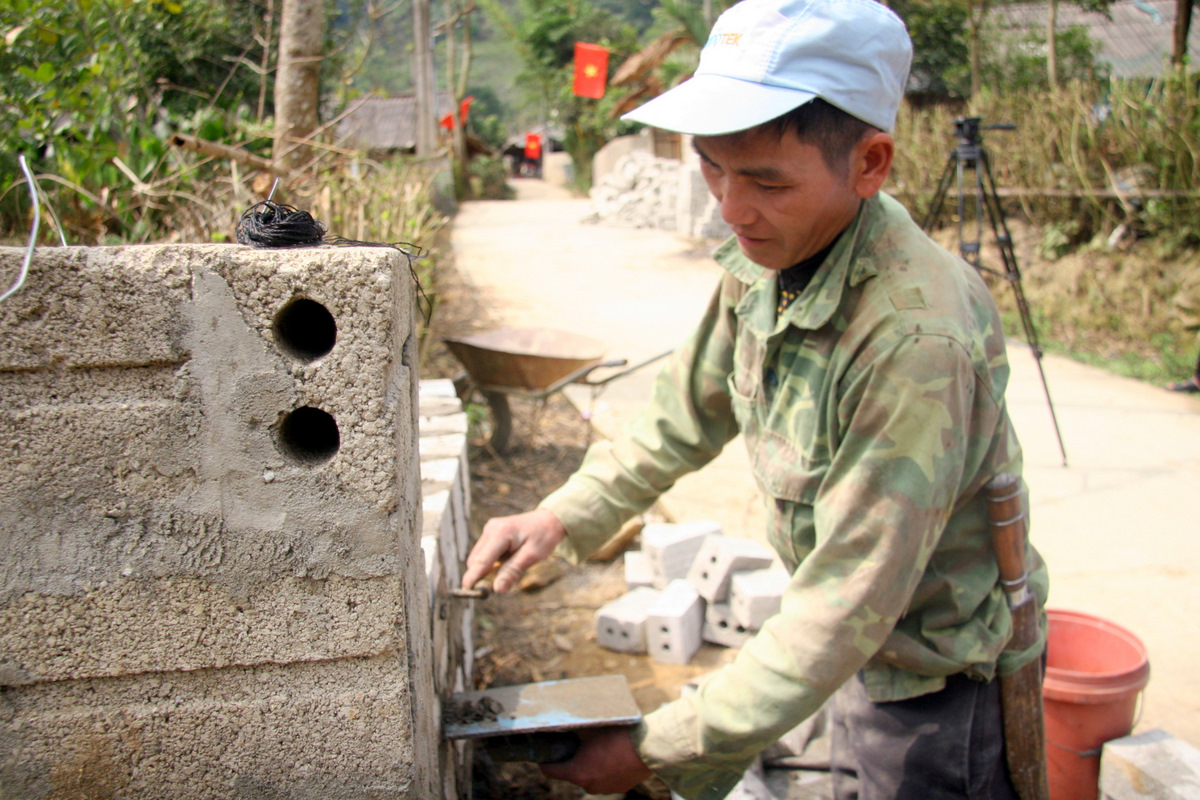 Người dân bản Huổi Bắc, xã Pha Mu (huyện Than Uyên) xây dựng cổng nhà theo mô hình “Nhà sạch kiểu mẫu”.